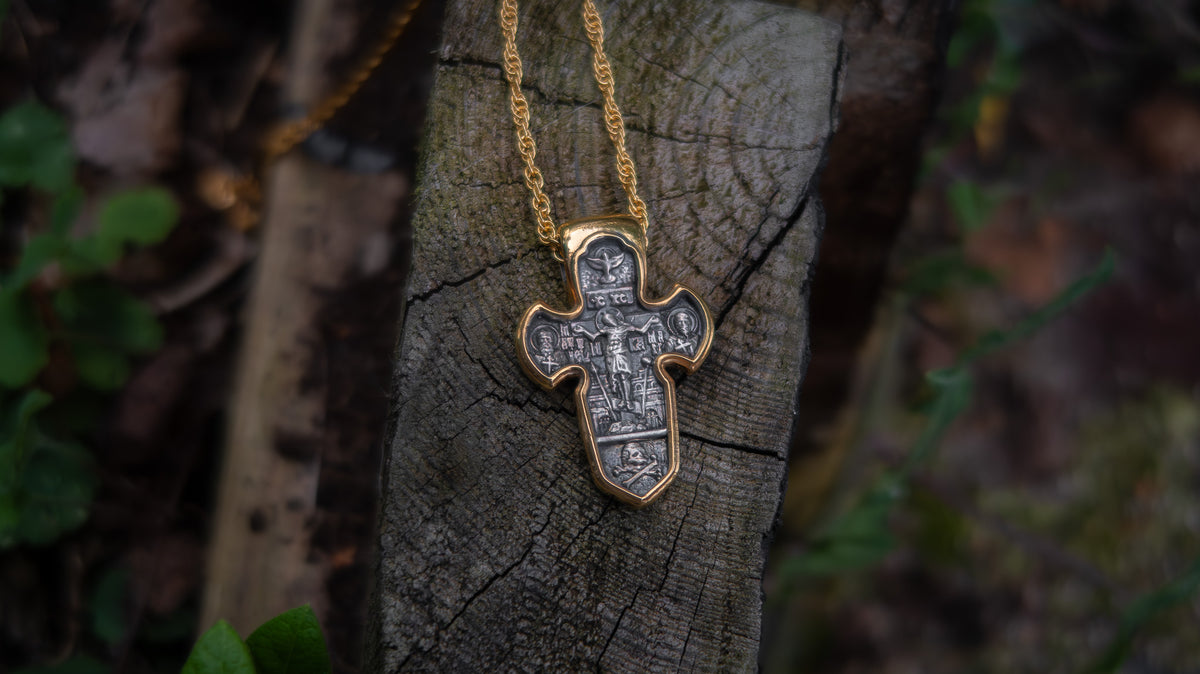 Gold cross necklace on a tree stump with a natural background